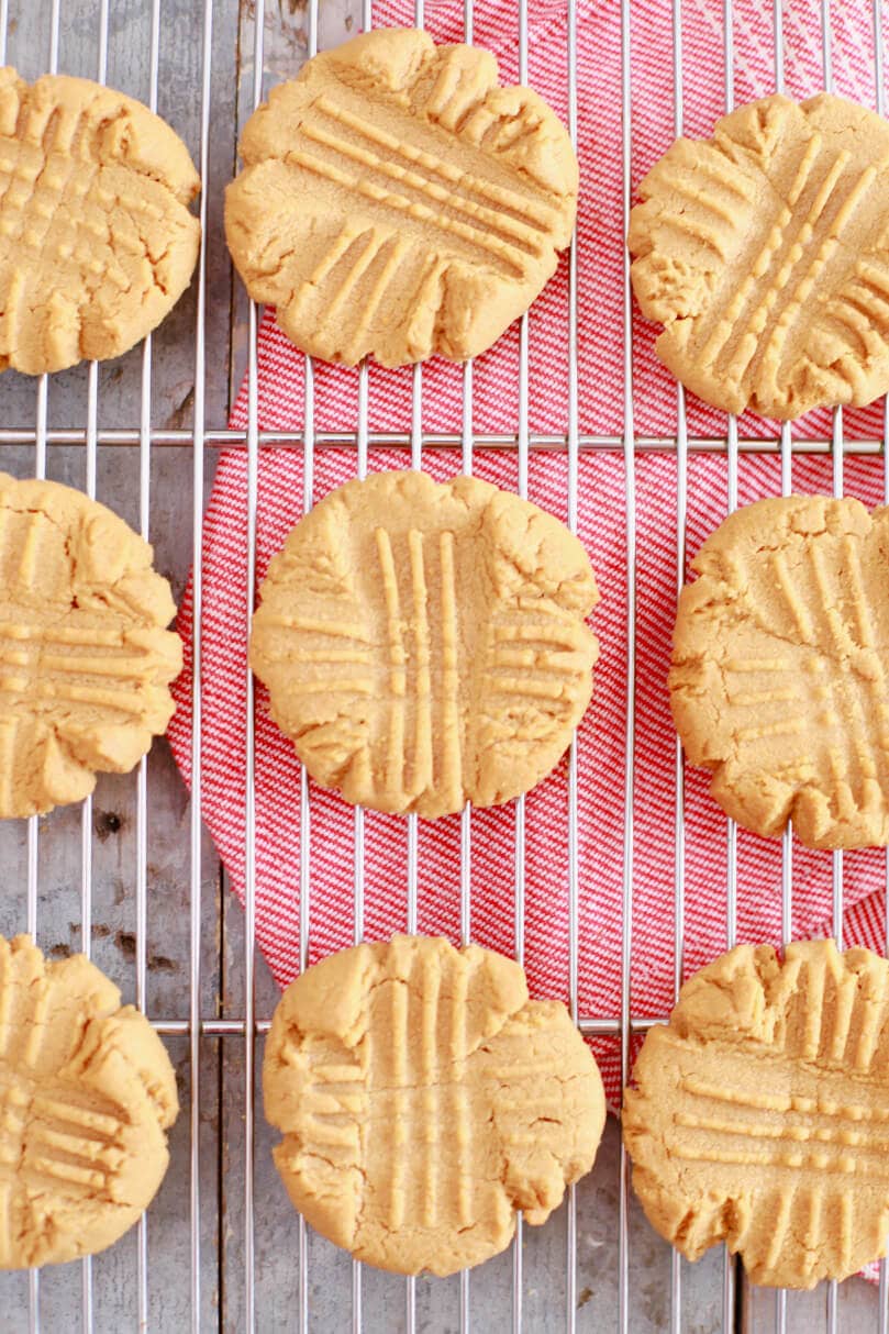 A wire rack with 3-Ingredient Peanut Butter Cookies lying on them.