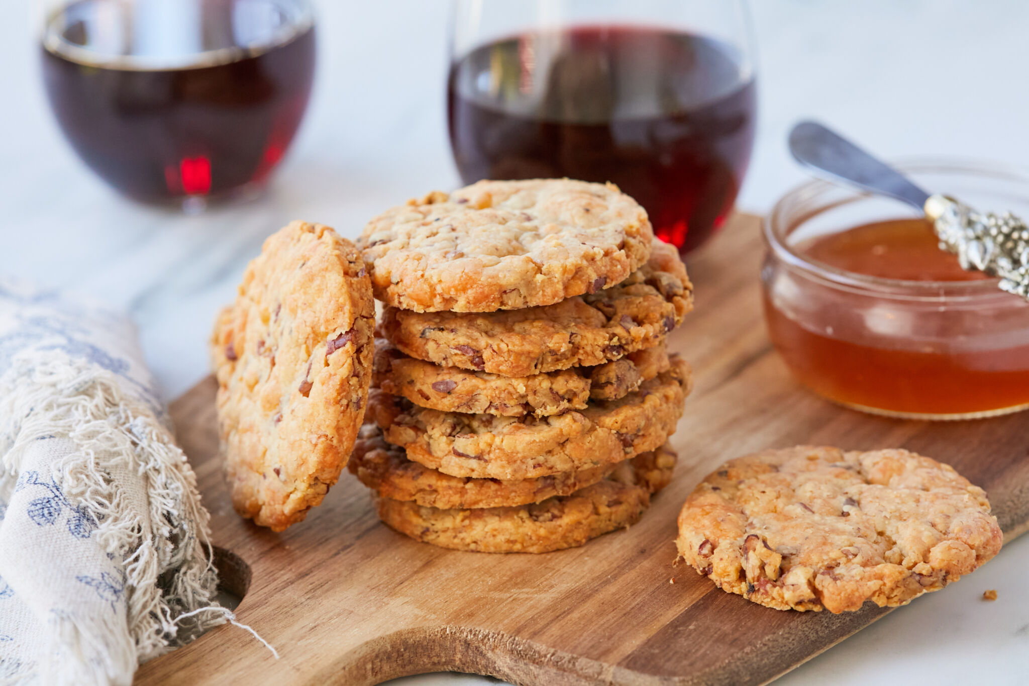 Savory, crispy, and crumbly cheesy cheddar and pecan shortbread cookies served with wine and honey.