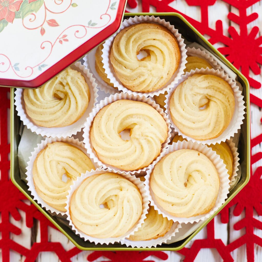 Buttery, crispy and crumbly Danish Butter Cookies are stored in a tin with individual liners.