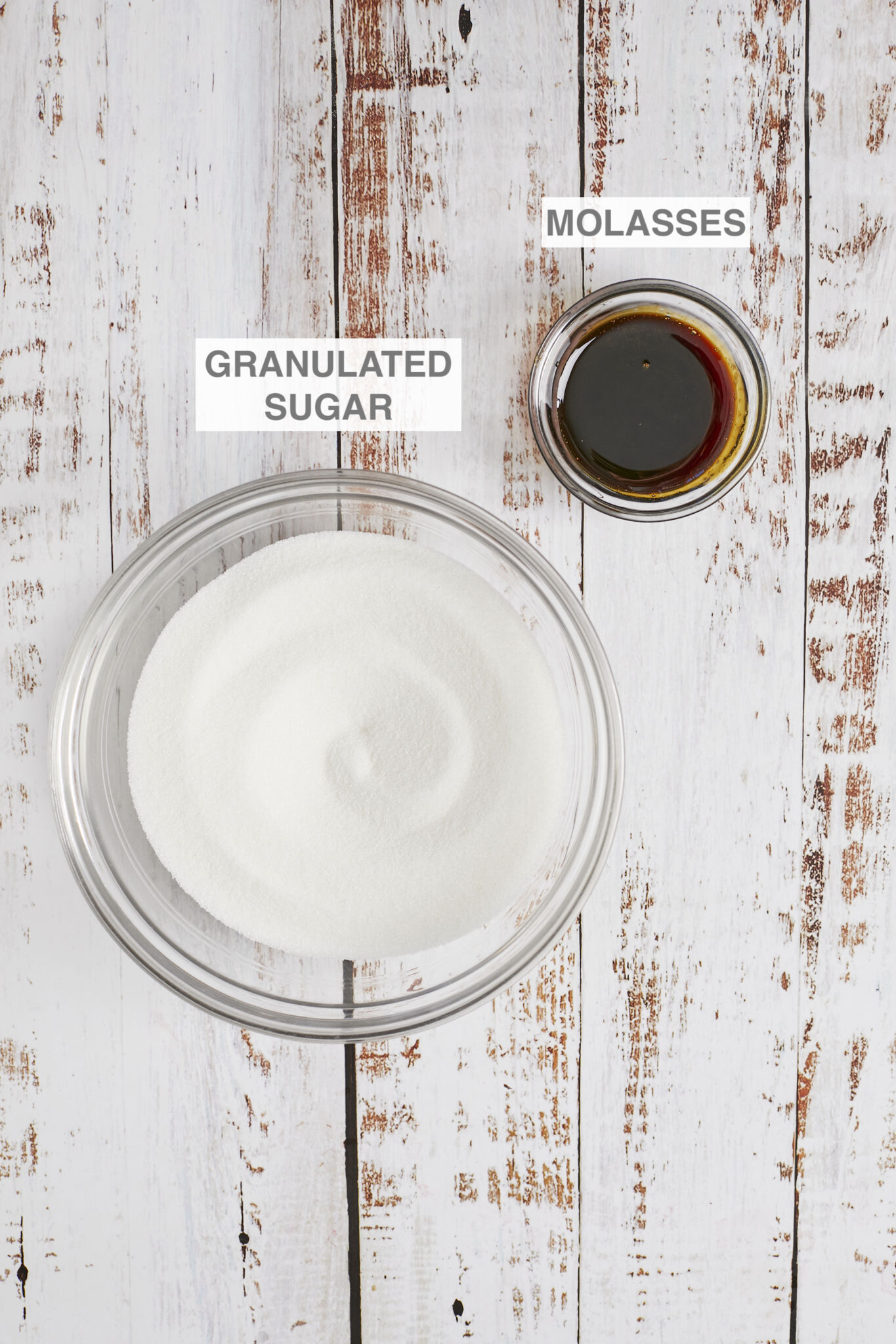Ingredients for Homemade Brown Sugar are granulate white sugar an molasses in glass bowls. 