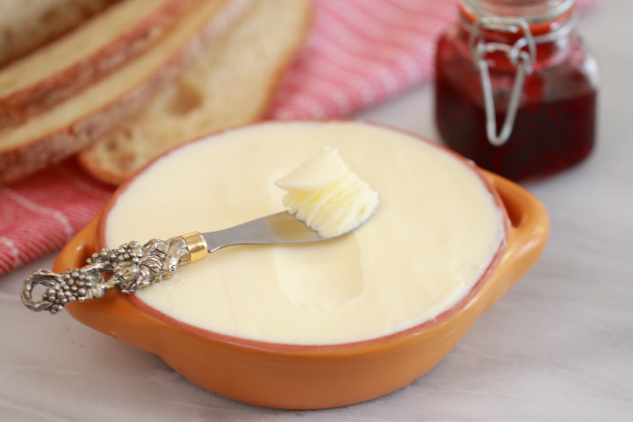 Homemade butter in a small bowl with a butter knife