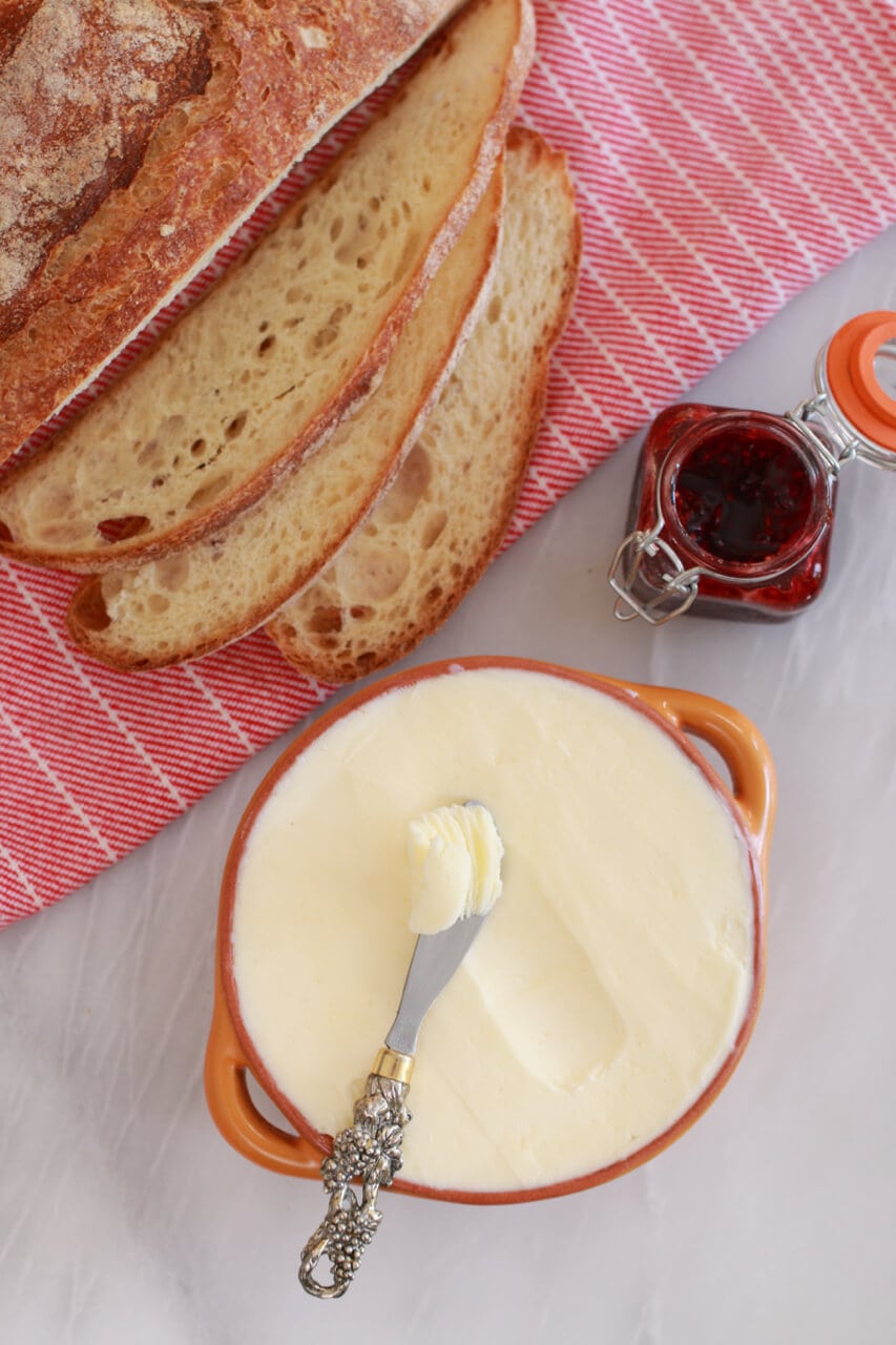Homemade butter with jam and slices of bread.