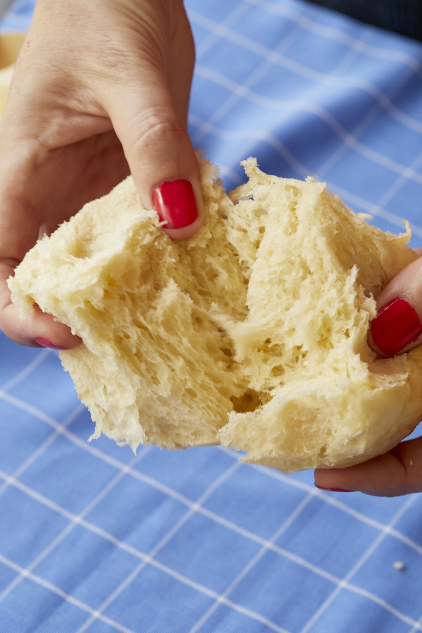 Splitting one dinner roll into half shows the soft interior, fine crumb and perfect gluten strands.