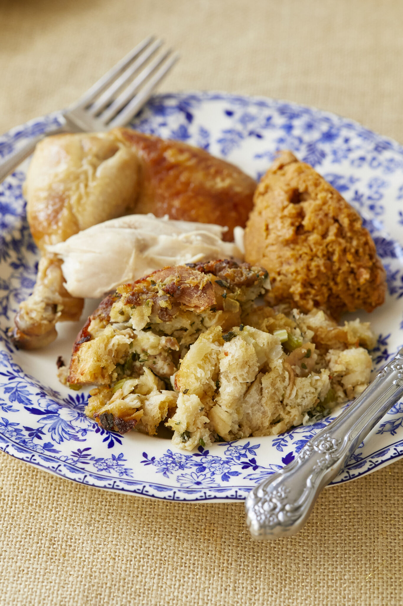 Classic Sage and sausage Stuffing is baked golden brown, with crispy bits on the outside and moist inside, paired with turkey and sweet potato soufflé served on a floral Devon Cottage plate. 