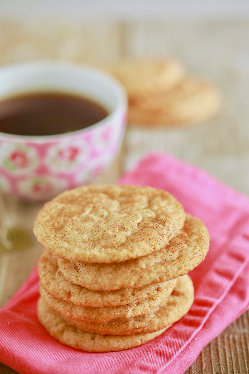 A stack of Soft Chewy Snickerdoodle cookies are served with a cup of coffee. 