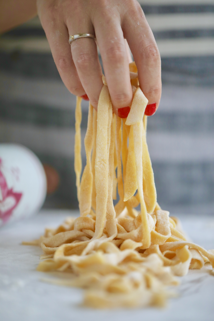 A hand picking up some of my homemade pasta.